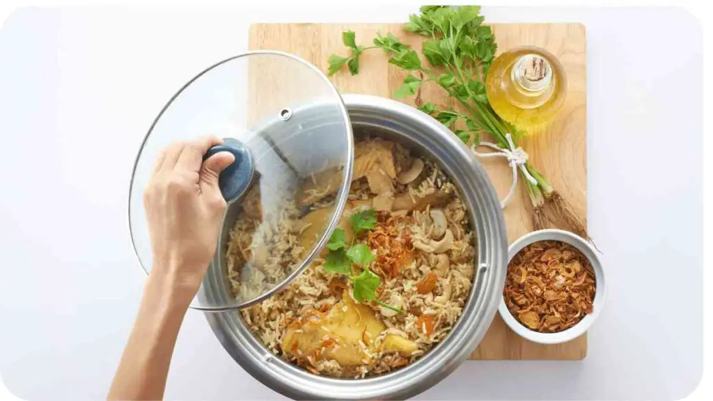 top view of a hand holding a pan with rice and vegetables on a white background stock photo