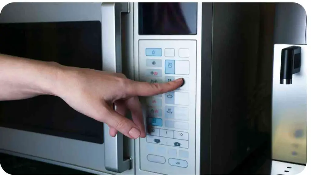 a person touching a button on a microwave