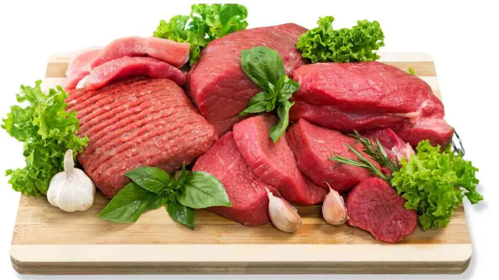 raw meat and vegetables on a cutting board